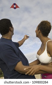 African American Couple Flying Kite On Beach