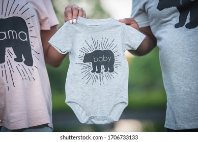 African American Couple Holding Up Baby Onesie Clothing