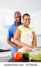 African American Couple Hugging In Kitchen