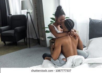 African American Couple Kissing On Bed In Bedroom