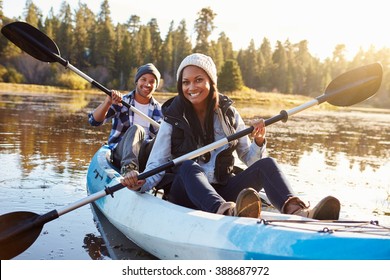 African American Couple Rowing Kayak On Lake