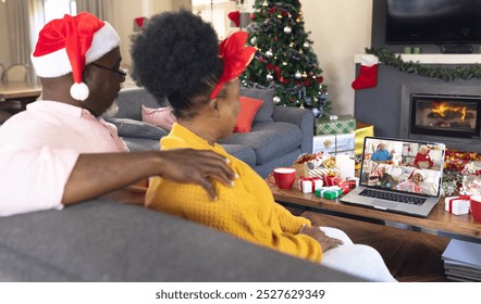 African american couple with santa hat having video call with happy diverse friends. Christmas, celebration and digital composite image. - Powered by Shutterstock