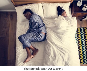 African American couple sleeping back to back - Powered by Shutterstock