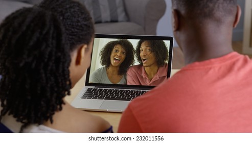 African American Couple Talking To Family Over Video Chat On Laptop