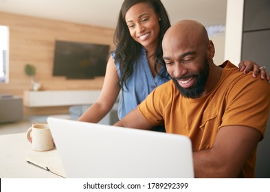 African American Couple Using Laptop To Check Finances At Home