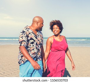 African American couple walking at the beach