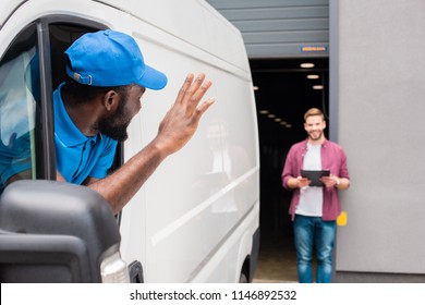 African American Courier Waving Hand To Client