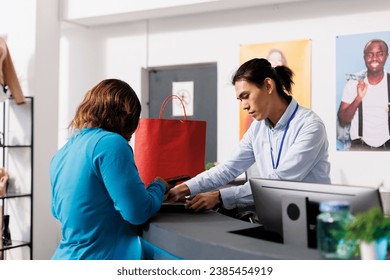 African american customer paying for clothes at counter desk in clothing store, putting credit card on pos. Shopaholic woman shopping for casual wear in modern botique. Fashion concept