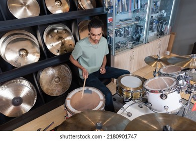 African American Customer Playing Drum Set In Music Store