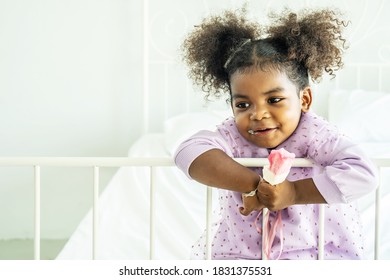 African American Cute Baby Girl  Holding Eating Ice Cream  On Bed In Bedroom