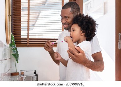 African American Dad and little son brushing teeth together. - Powered by Shutterstock