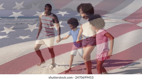 African American dad, son, daughter, and biracial mom walk on beach. They are enjoying sunny day, all dressed in light summer clothes - Powered by Shutterstock