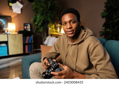 African American dark skinned photographer, holding his camera and checking the settings before capturing a stunning shot. - Powered by Shutterstock