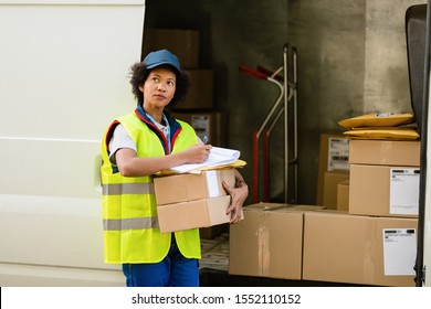 African American Delivery Woman Filling Paperwork While Getting Ready For Package Delivery, 