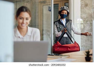 African American Delivery Woman Wearing Face Mask While Doing Food Delivery At Business Office.