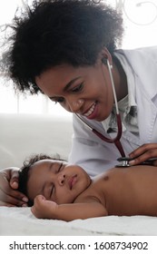 african american doctor checking up health of black baby girl with stethoscope
