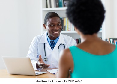 African American Doctor With Good News For Female Patient At Hospital