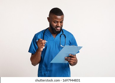 African American Doctor Making Check Up, Filling Medical Form Over White Background