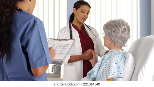 African American Doctor And Nurse Talking To Elderly Patient