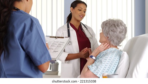 African American Doctor And Nurse Talking To Elderly Patient