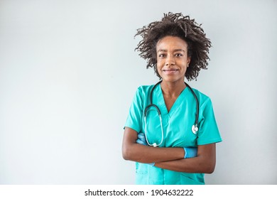 African American Doctor Standing In Her Office At Clinic. Waist Up Portrait Of Beautiful African-American Nurse Posing Confidently While Standing With Arms Crossed Against Gray Background, Copy Space