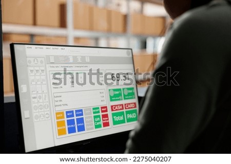 African american employee analyzing goods checklist on computer, working at merchandise inventory in storehouse. Stockroom worker checking customers orders during products quality control
