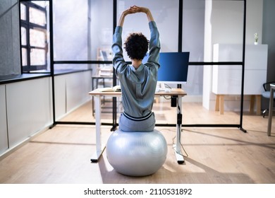 African American Employee Exercising On Ball In Office - Powered by Shutterstock