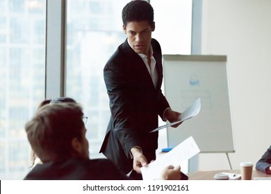 African American employee share handout material to colleagues at company meeting in office, team leader or presenter give printed plan or work results, making flipchart presentation at briefing - Shutterstock ID 1191902161