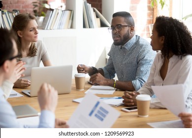 African American Employee Talk At Briefing Expressing Point Of View, Multiracial Millennial Workers Brainstorm In Boardroom Discussing Project Report, Diverse Colleagues Negotiate At Business Meeting