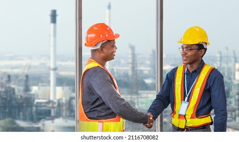 African American Engineer And Security Team Handshaking For Agreement In Partnership Project For Petroleum And Crude Oil Refinery Factory For Power Industry