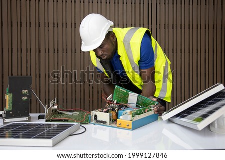 African American engineer is working on setting up solar panel circuit for sustainable energy resource with copy space for industrial usage