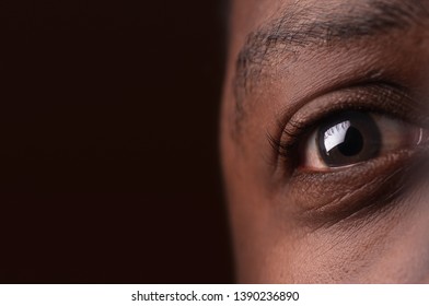 African American Eye Close Up On Dark Brown Background