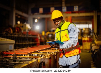 African american factory worker checking with clipboard in metal sheet manufacture. supporting engineer, factory worker working in  management system for metal sheet factory, construction. - Powered by Shutterstock