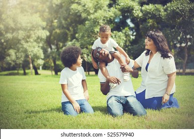 African American Family Alongside With Asian Mum Being Playful And Having Good Times In The Park