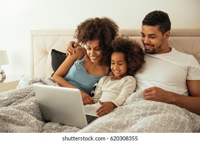 African american family bonding in bed. - Powered by Shutterstock