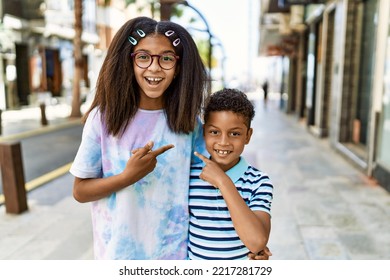African american family of bother and sister standing at the street smiling happy pointing with hand and finger 
