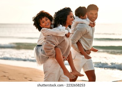 African American family with a cute curly daughter in a white dress and a little son on their backs walking and having fun on the sandy beach by the sea at dawn. - Powered by Shutterstock