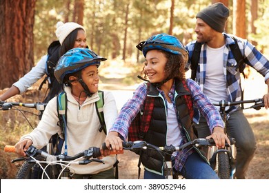 African American Family Cycling Through Fall Woodland