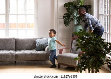 African American Family Dad And Kid Have A Fun Playing Tags Touch Game Spend Free Time On Weekend At Home. Cheerful Father And Little Preschool Toddler Son Catching Each Other Running In Living Room