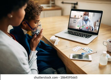 African American family doctor explaining online the procedure of inhaling therapy to mother and daughter at home during coronavirus pandemic. 