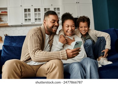 An African American family engrossed in a smartphone on a cozy couch. - Powered by Shutterstock