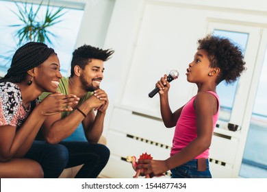 African American Family Enjoy Singing Karaoke At Home, Having Fun.