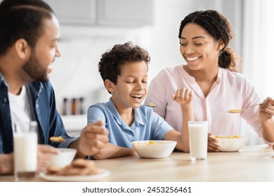 African American family enjoying a healthy breakfast together in a bright kitchen, showcasing family bonding - Powered by Shutterstock