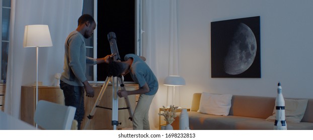 African American family - father and son, using telescope to explore moon surface. Stay home, learning from home, quarantie - Powered by Shutterstock