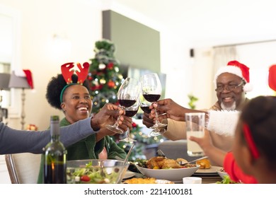 African American Family Having Christmas Meal And Drinking Wine. Christmas, Family Time And Celebration Concept.