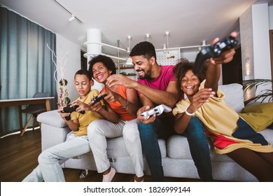 African American Family At Home Sitting In Sofa Couch And Playing Video Games Together