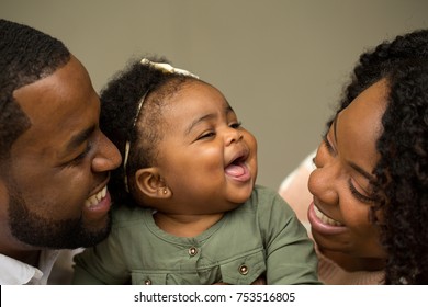 African American family laughing with their little girl.