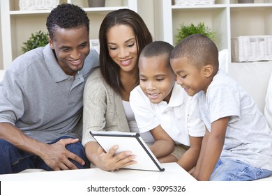 African American family, mother & father parents and two sons, having fun using a tablet computer together at home