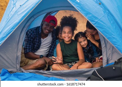 african american family, parent with kids, and asian adoped child having fun together in camping at natural park - Powered by Shutterstock