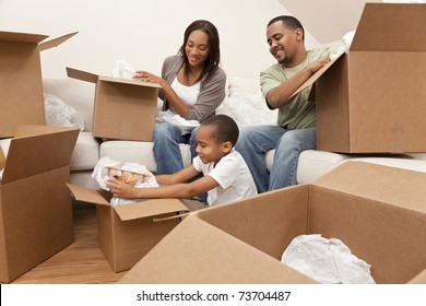 African American family, parents and son, unpacking boxes and moving into a new home, The adults are unpacking crockery and houseware, the child is unpacking a toy airplane. - Powered by Shutterstock